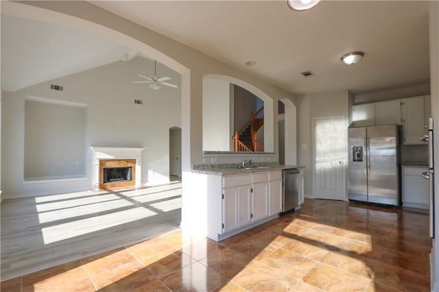 kitchen featuring visible vents, arched walkways, ceiling fan, appliances with stainless steel finishes, and white cabinetry