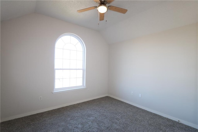 carpeted spare room featuring vaulted ceiling, ceiling fan, and baseboards