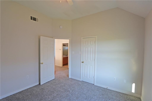 unfurnished room featuring carpet floors, a ceiling fan, visible vents, vaulted ceiling, and baseboards