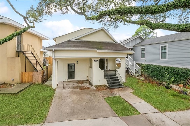 exterior space with a tiled roof, fence, stairway, and stucco siding