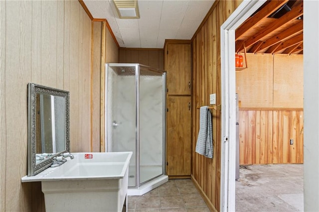 full bath featuring a stall shower, tile patterned flooring, wooden walls, and visible vents