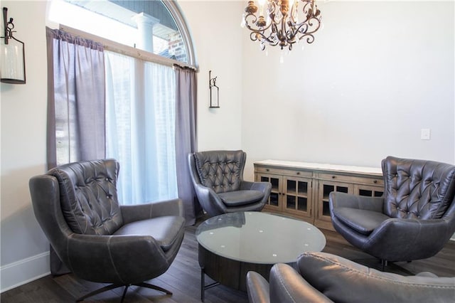 sitting room with a chandelier, wood finished floors, and baseboards