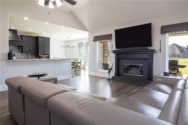 living room with baseboards, dark wood-style floors, vaulted ceiling, a fireplace, and recessed lighting