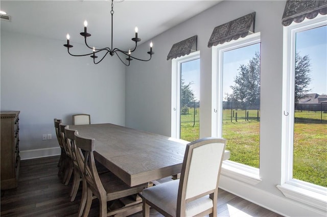 dining space featuring baseboards, dark wood finished floors, and a notable chandelier