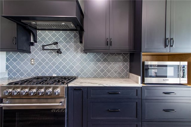 kitchen featuring stainless steel appliances, backsplash, wall chimney range hood, and light stone counters