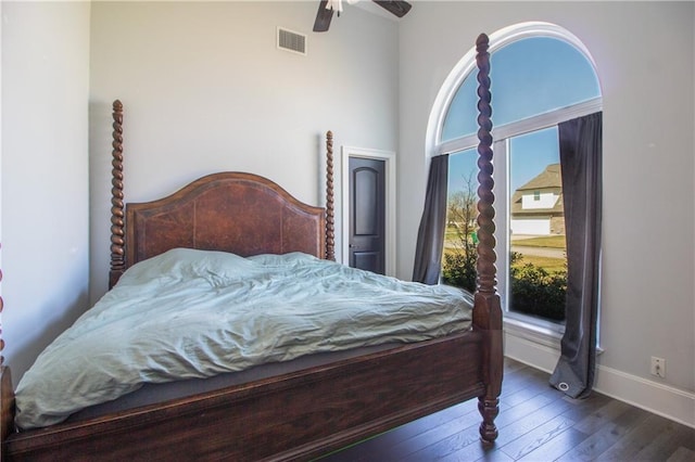 bedroom with multiple windows, dark wood finished floors, visible vents, and baseboards