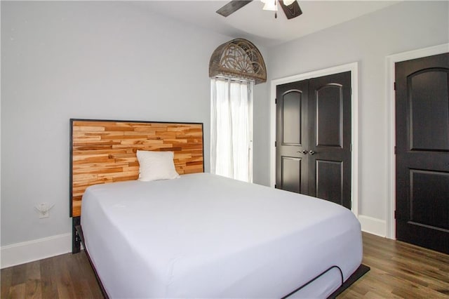 bedroom featuring ceiling fan, a closet, baseboards, and wood finished floors