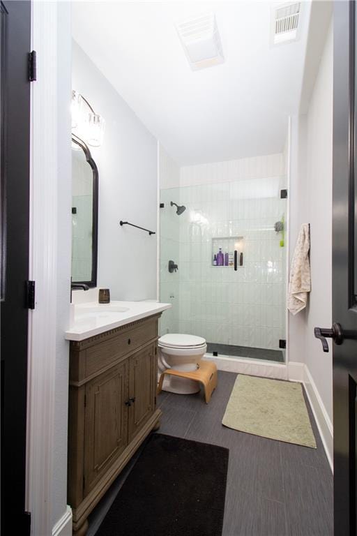 full bath with visible vents, baseboards, toilet, vanity, and a shower stall