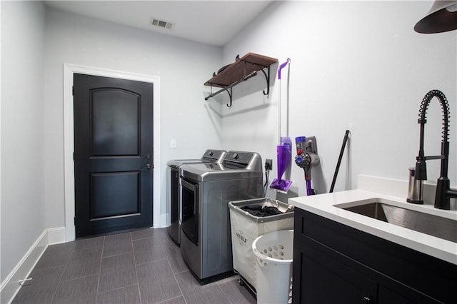 laundry area featuring cabinet space, baseboards, visible vents, washing machine and clothes dryer, and a sink