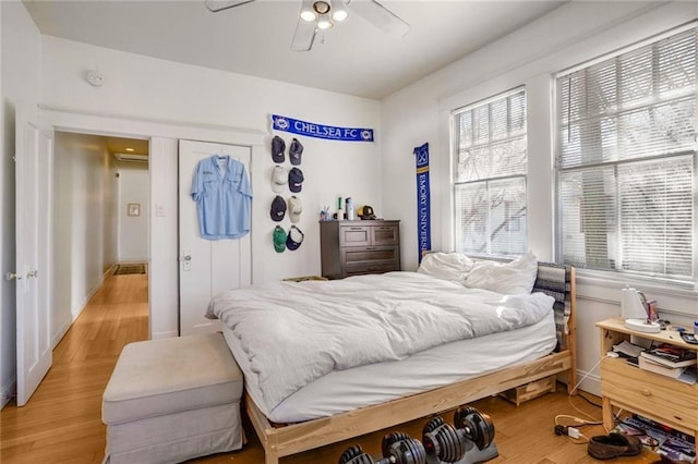 bedroom featuring multiple windows, light wood-type flooring, and a ceiling fan