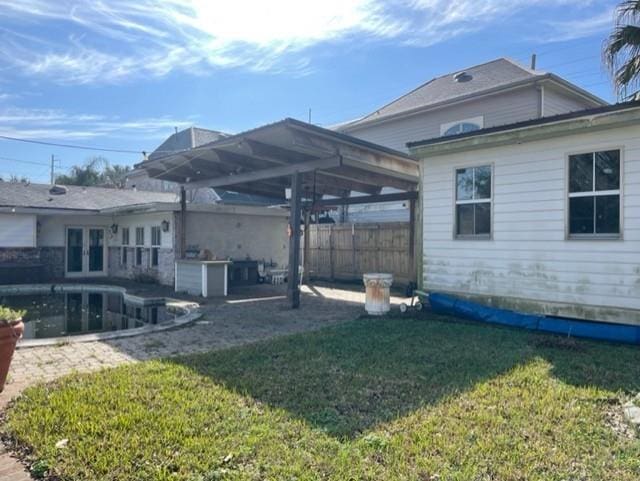 back of house with french doors, a patio area, and a yard