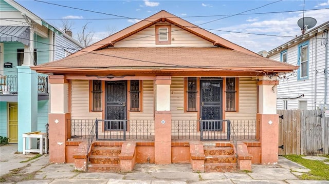 view of front of property featuring a porch and fence