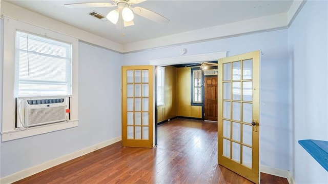 empty room featuring baseboards, visible vents, wood finished floors, cooling unit, and french doors