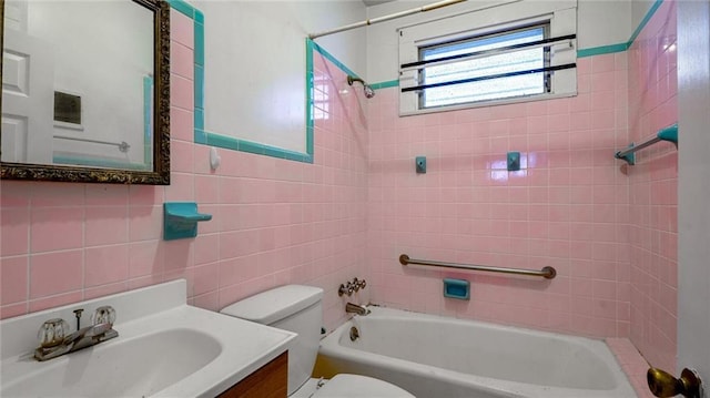 full bathroom featuring tub / shower combination, vanity, toilet, and tile walls