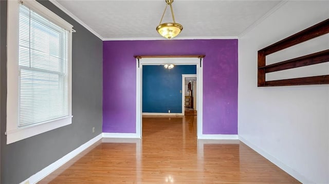 unfurnished dining area with baseboards, crown molding, and wood finished floors