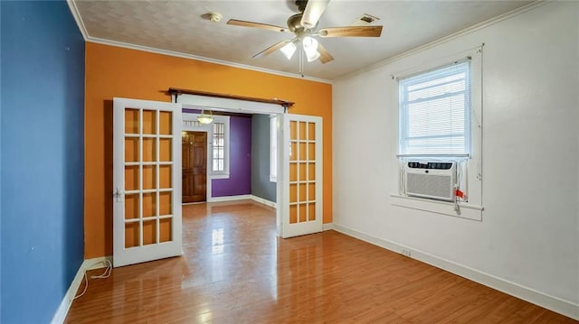 unfurnished room with plenty of natural light, french doors, crown molding, and wood finished floors