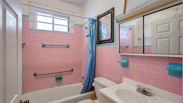 bathroom featuring toilet, tile walls, shower / tub combo with curtain, and vanity