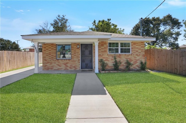 bungalow-style home featuring brick siding, a front yard, and fence