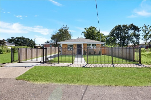 view of front of home featuring a fenced front yard, brick siding, a front lawn, a gate, and concrete driveway