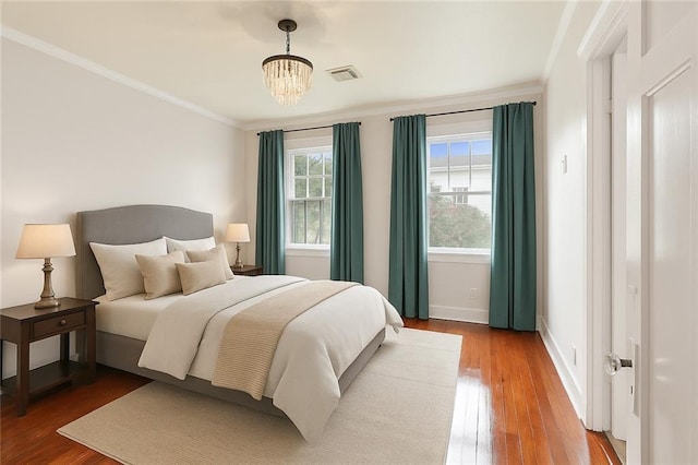 4500 S Rocheblave St, New Orleans, LA 70125 - bedroom with wood finished floors, a chandelier, baseboards, and ornamental molding