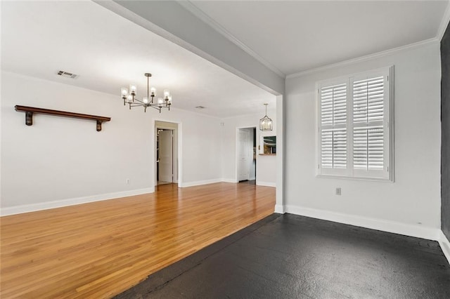 empty room with wood finished floors, visible vents, baseboards, an inviting chandelier, and crown molding