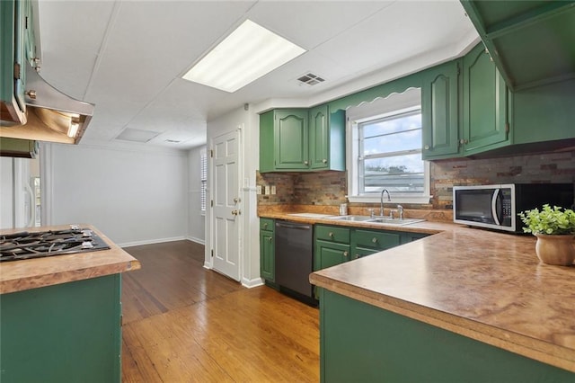 kitchen featuring a sink, visible vents, green cabinets, appliances with stainless steel finishes, and tasteful backsplash