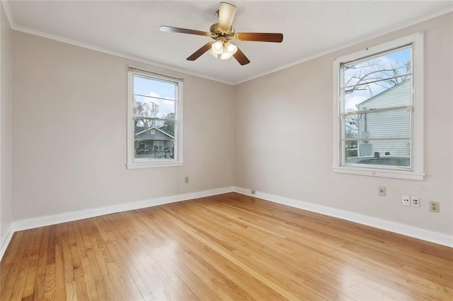 spare room featuring light wood-style floors, a ceiling fan, baseboards, and crown molding