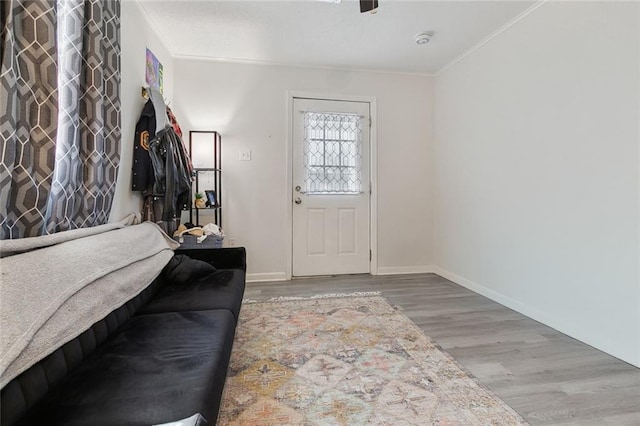 foyer with ornamental molding, baseboards, and wood finished floors