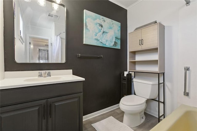 bathroom featuring baseboards, visible vents, toilet, ornamental molding, and wood finished floors