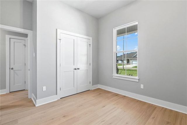 unfurnished bedroom with light wood-style flooring and baseboards