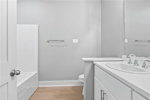 full bath with vanity, wood finished floors, toilet, and baseboards