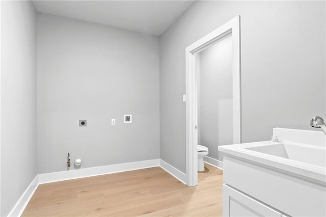 washroom featuring laundry area, hookup for an electric dryer, light wood-type flooring, washer hookup, and a sink