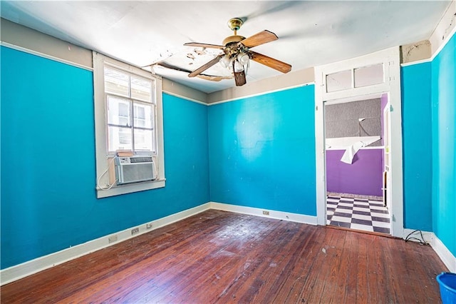 spare room with a ceiling fan, cooling unit, wood-type flooring, and baseboards