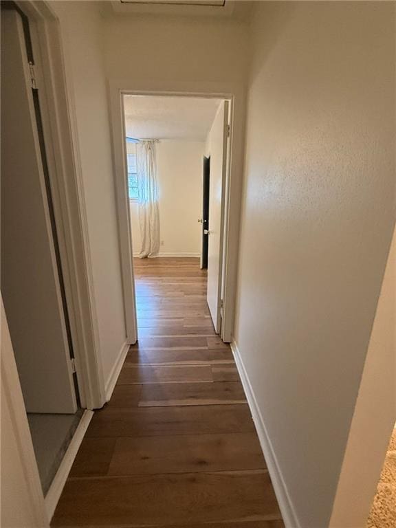 hall with dark wood-style floors and baseboards