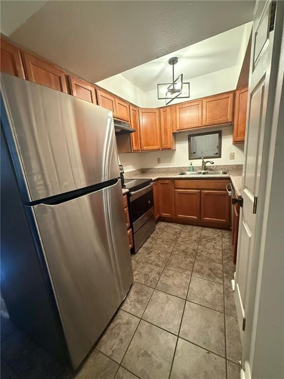 kitchen featuring stainless steel appliances, brown cabinetry, light tile patterned flooring, a sink, and under cabinet range hood