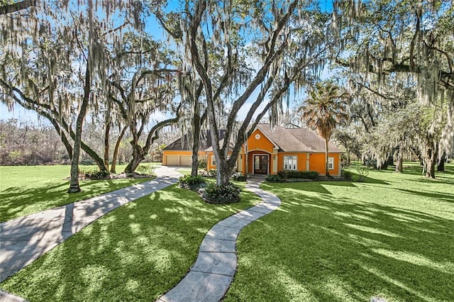 view of front of home featuring a garage, concrete driveway, and a front yard