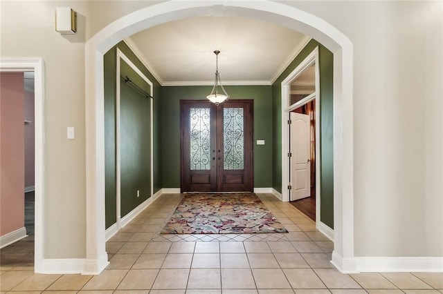 entrance foyer with light tile patterned floors, baseboards, and arched walkways