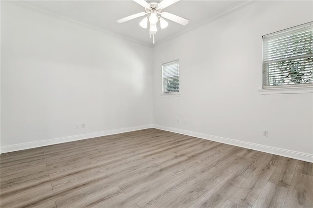 spare room featuring a ceiling fan, crown molding, baseboards, and wood finished floors