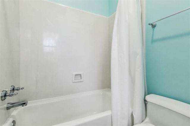 bathroom featuring toilet and shower / bathtub combination with curtain