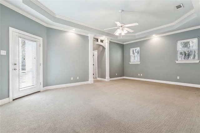 carpeted spare room featuring a wealth of natural light, a tray ceiling, baseboards, and a ceiling fan