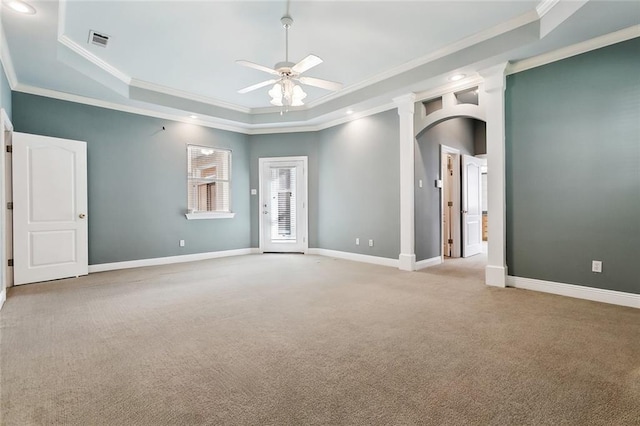 empty room featuring arched walkways, a raised ceiling, visible vents, and baseboards