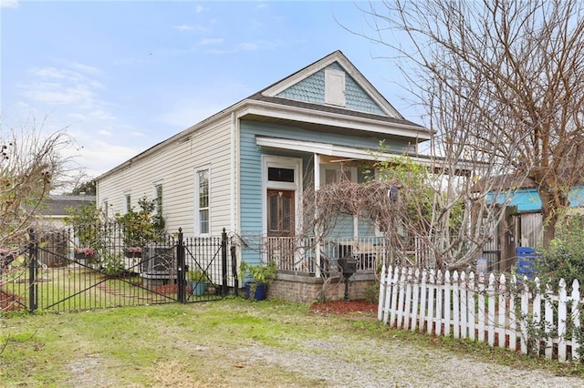 view of front of house with covered porch, a front yard, fence, and a gate