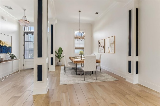 dining room with crown molding, light wood finished floors, visible vents, and an inviting chandelier