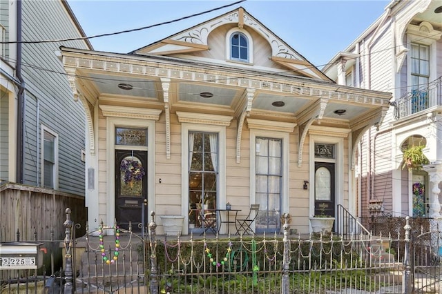 view of front of house featuring covered porch and a fenced front yard