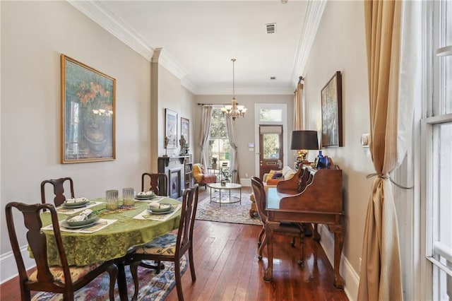 dining space featuring a notable chandelier, visible vents, dark wood-type flooring, ornamental molding, and baseboards