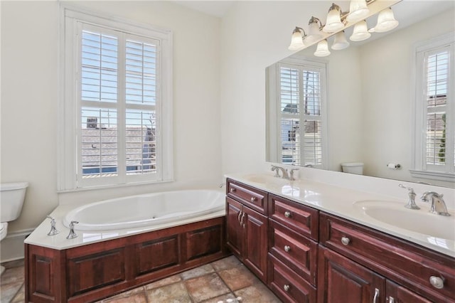 full bath with a garden tub, double vanity, a sink, and toilet