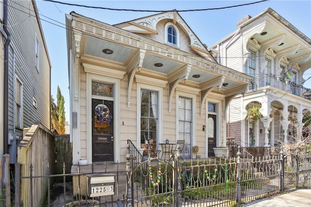 shotgun-style home featuring a fenced front yard