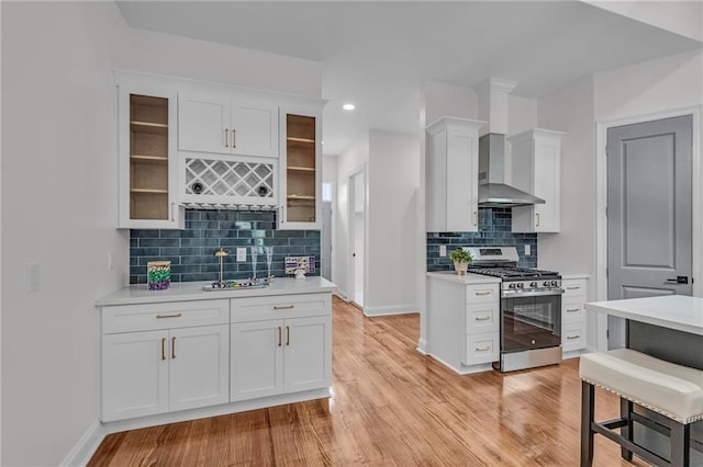 kitchen featuring gas stove, white cabinets, and light countertops