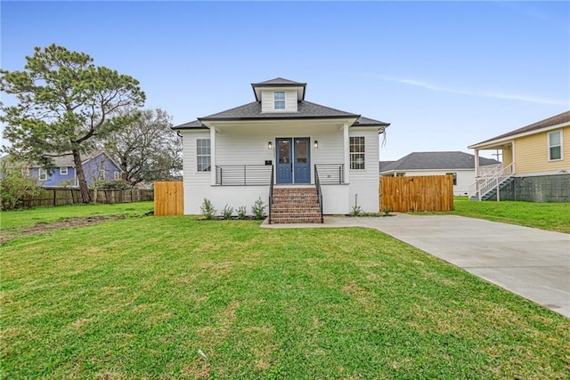 view of front of house featuring a front yard, brick siding, and fence