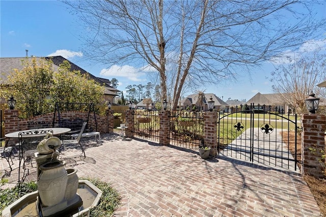 view of patio / terrace featuring a gate, outdoor dining area, fence, and a residential view